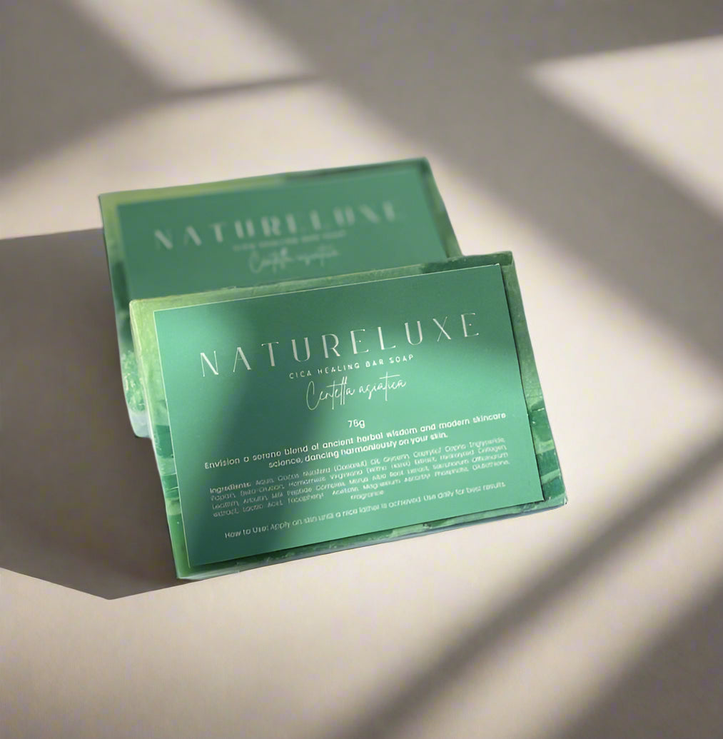 Two green soap bars with 'NATURELUXE' branding on a white fabric background